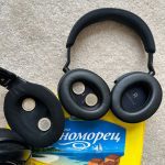 a pair of black headphones with coins on top of a yellow book